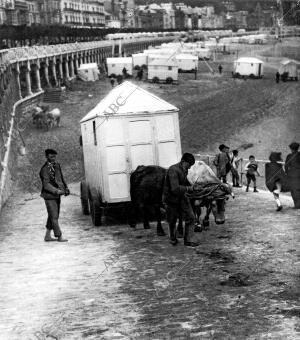 Los bañeros subiendo las casetas instaladas en la playa a lugares donde no las...