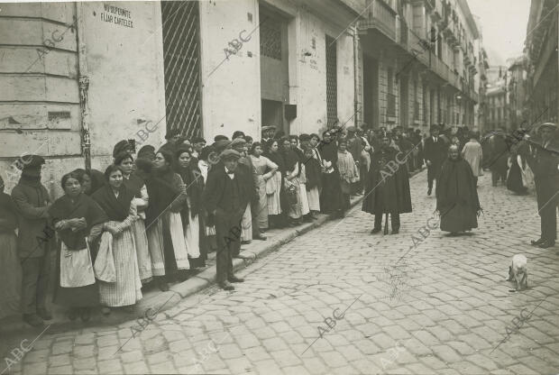 El público formando cola a la puerta de una panadería de la calle de Santa...
