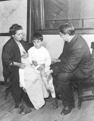 El doctor Nichols, jefe del comité de higiene de nueva York, examinando un niño...