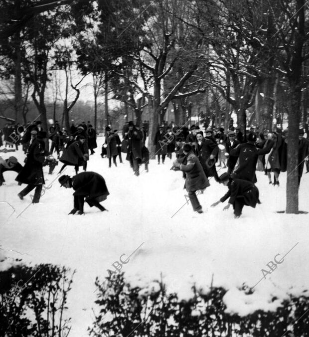 Jóvenes Difrutando de la nieve en el parque del retiro