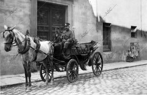 Un coche de Alquiler, Custodiado por un guardia municipal en el Pescante, al...