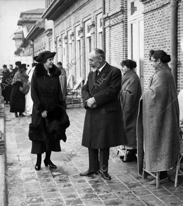 S.M. la Reina (1), Acompañada del doctor Codina (2), durante su visita de ayer...