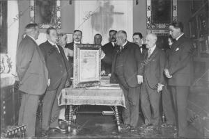 El doctor D. Francisco Huertas (X) Recibiendo el artístico pergamino que ayer le...