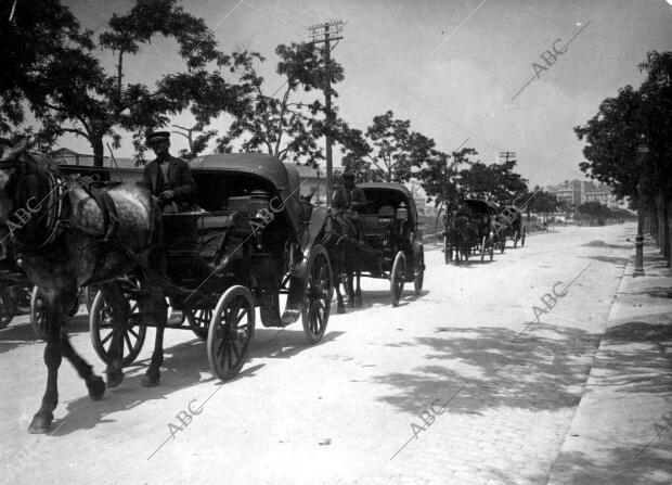 Fila de coches de caballos por las calles de Madrid