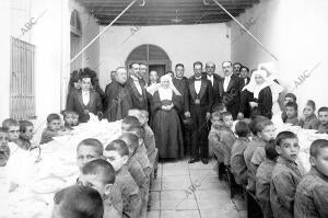 Las Autoridades Prsenciando la comida dada A los Niños Asilados el Dia de san...