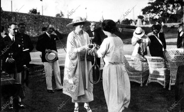 S.M. la Reina Doña Victoria (x) entregando a la Srta