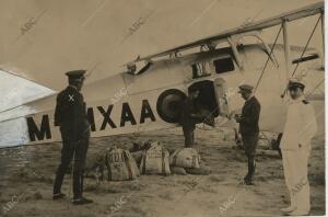 El general Echague (x) presenciando la carga de correo en uno de los aviones que...