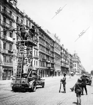 Ingenieros de la Compañia de Tranvias Reparando los Cables, Custodiados por la...