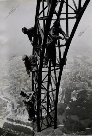 Obreros pintores trabajando, a 300 metros de altura, en el repintando de la...