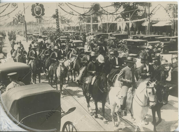 Ambiente en el Real de la Feria, con caballistas, coches de caballos y...