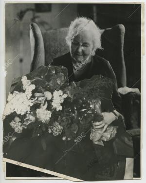 Montaje fotográfico de una abuela con un ramo de fotos, publicado en 1935