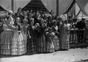 Mujeres vestidas con traje de gitana posando en la puerta de la caseta del...