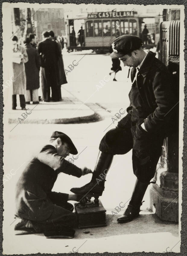 Un hombre Limpiando las Botas A un Soldado, en Madrid