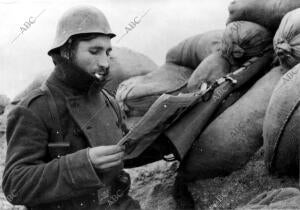 Un Soldado, en el frente de Madrid, Leyendo la prensa en un momento de descanso...