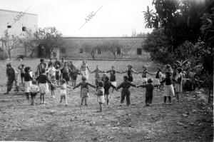 Los niños evacuados a Valencia, jugando en el huerto del Socorro Rojo...