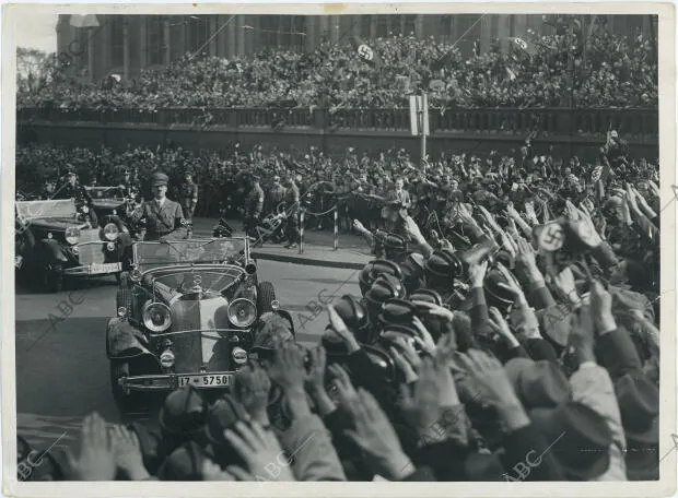 Hitler saluda, desde su Mercedes descapotable, a las multitudes congregadas para...