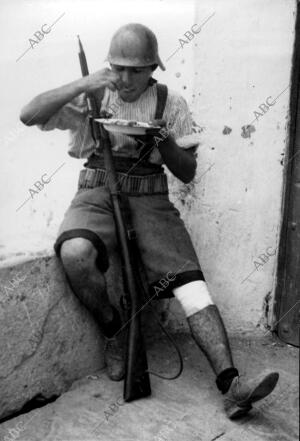 Un miliciano Tomando un plato de arroz A la Valenciana, después del Combate, en...