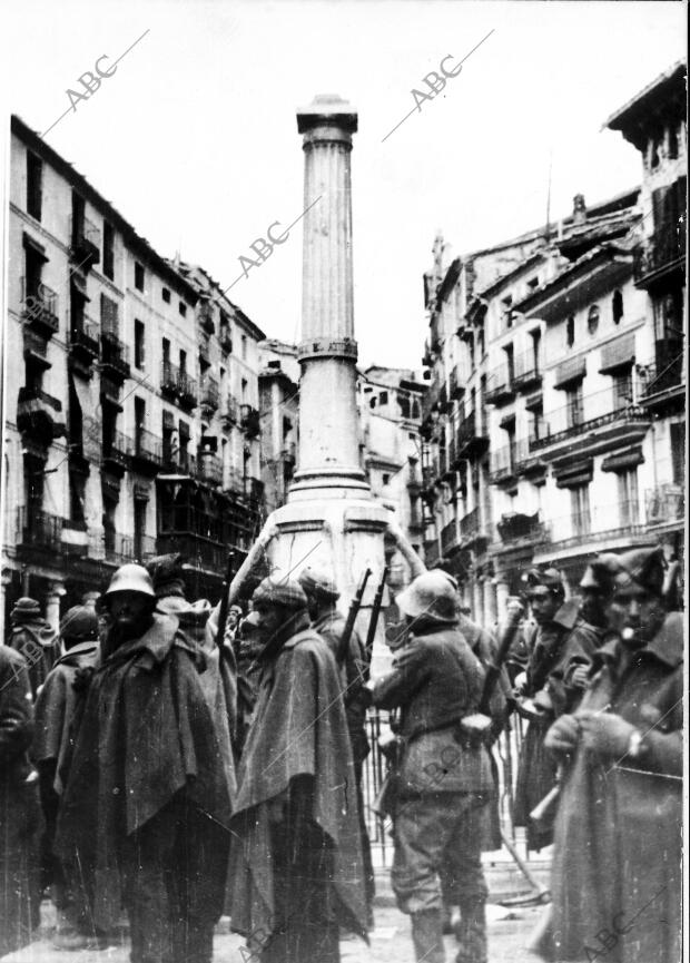 Los Combatientes precariamente Abrigados en torno al monumento de la turolense...