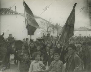 Mujeres y niños portando banderas, dando la bienvenida a la nueva España tras la...