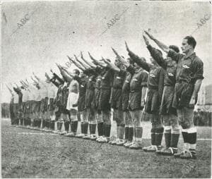 En la imagen, los equipos saludan brazo en alto, durante su presentación