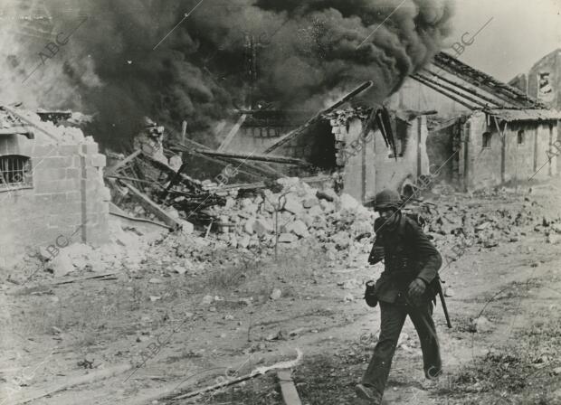 Entre ruinas humeantes que casi borran el trazado de las calles, la Infantería...