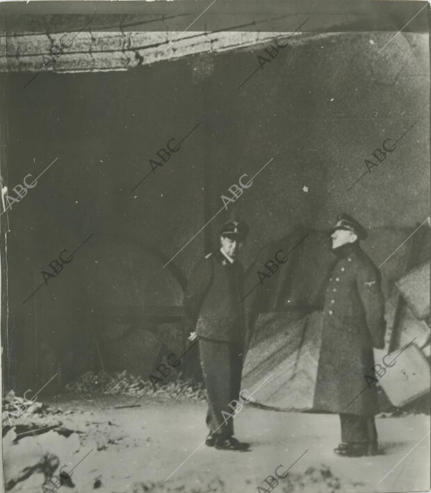 Adolf Hitler y su edecán Julius Schaub, contemplan las ruinas de la Cancillería...