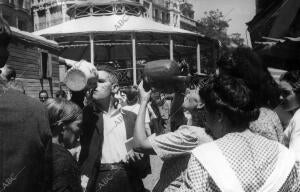 Personas bebiendo en botijos para refrescarse del calor