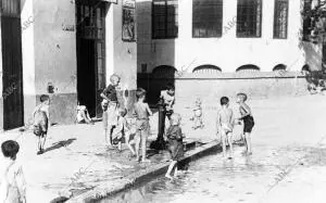 Niños Refrescándose en una fuente en la calle Pagés del corro en Triana - -fecha...