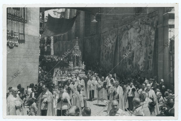 La custodia pasa bajo el arco de palacio, junto a los muros de la Catedral,...