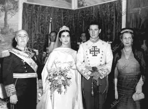 El general Franco, padrino de la ceremonia posa con los Reienc Casados y la...