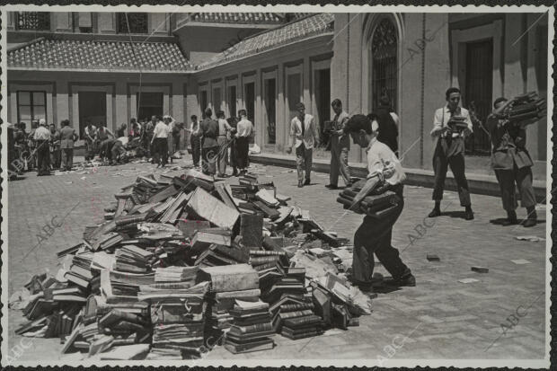En la imagen, grupos de voluntarios sacan libros de la bibloteca