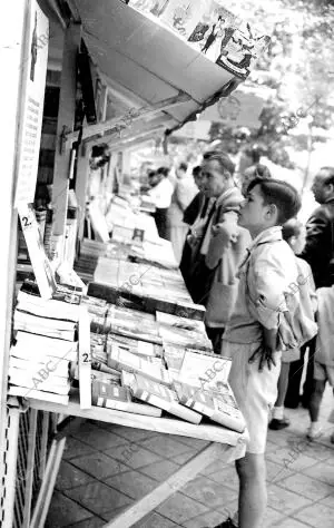 Un grupo de personas pasea y observa los puestos de libros de la Feria Nacional...