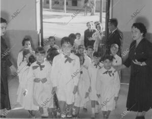 En la imagen, un grupo de niños van camino de clase