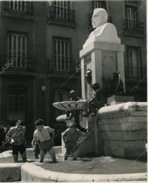 Los niños se refrescan en la fuente del monumento a Vázquez de Mella en la plaza...