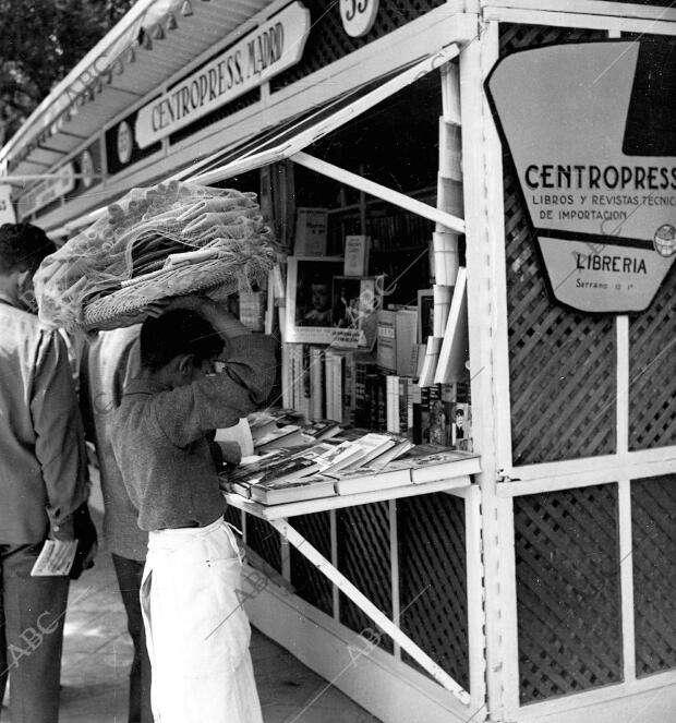 (CA.) Un barquillero viendo libros en una de las casetas de la Feria