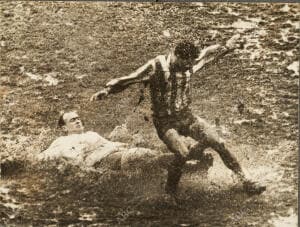 En la imagen, Di Stefano pelea por un balón en el suelo a Peiró, con un campo...