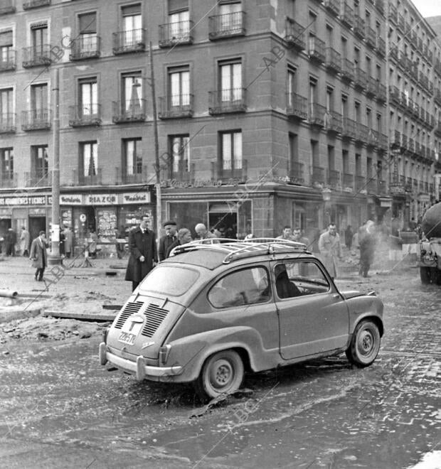 Un Seat 600 circulando por las calles de la capital, bajo la lluvia