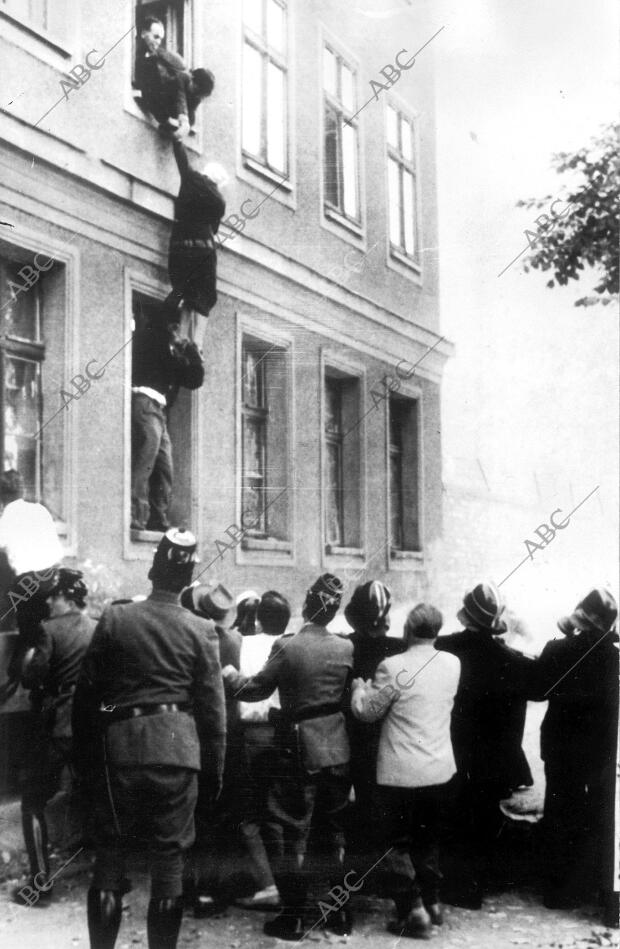 Para escapar de la zona comunista, una anciana de 77 años de edad es ayudada a...