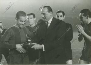 El futbolista del F.C. Barcelona Luis Suárez recibe de manos del representante...