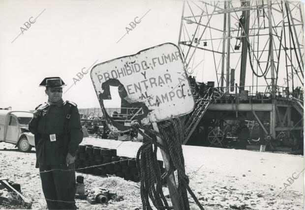 Un guardia civil sostiene un pitillo junto al cartel que advierte que está...