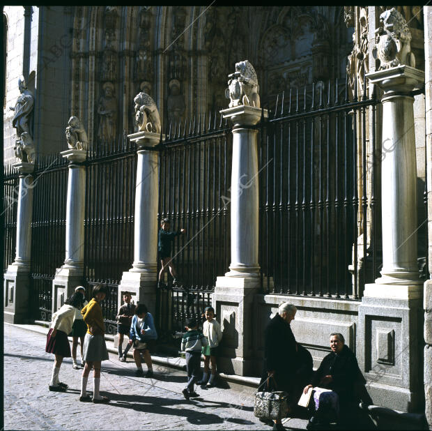 Unos niños juegan junto a la Puerta de los Leones de la Catedral