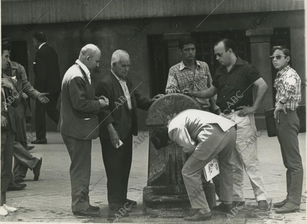Personas bebiendo en la fuente situada en la calle de Alcalá esquina a la plaza...