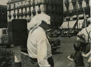 Un hombre espera el cruce de un semáforo en la Puerta del Sol, con un pañuelo en...