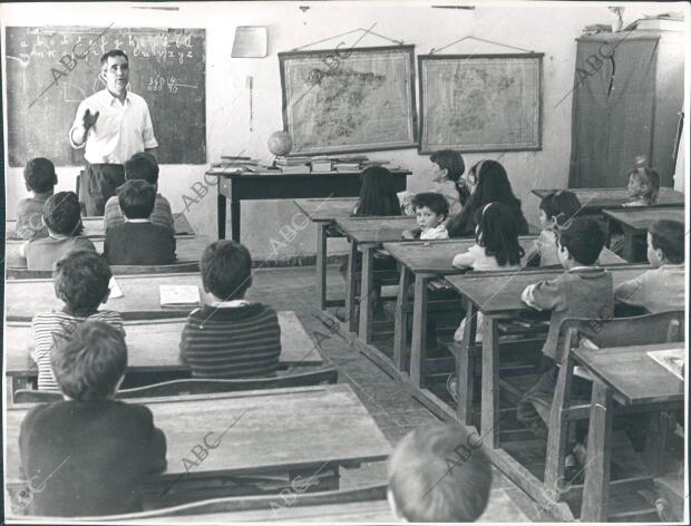 Los niños atienden las explicaciones de su maestro, Don Esteban García, pariente...