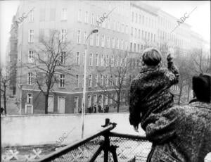 Un pequeño berlinés occidental saluda a su abuela (en el lado este), que le ha...