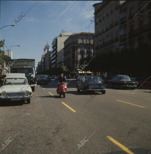 Tráfico en la calle de Serrano, con una vespa circulando a la derecha de un seat...