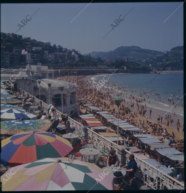 La playa de la Concha rebosa de bañistas, sombrillas y toldos del colores