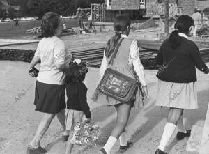 En la imagen, unas niñas llegando al colegio acompañadas por su madre