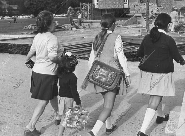 En la imagen, unas niñas llegando al colegio acompañadas por su madre