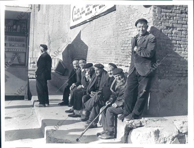 Un grupo de ancianos sentados al sol de invierno posan ante el fotógrafo de ABC